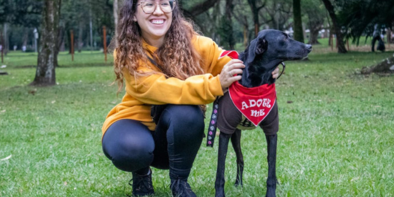 A picture of a woman with glasses putting a cloth in his dog